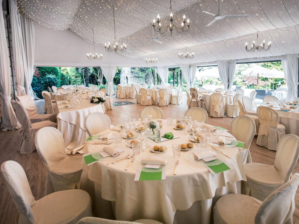 the inside of an event venue space. Set up with tables for a wedding reception.