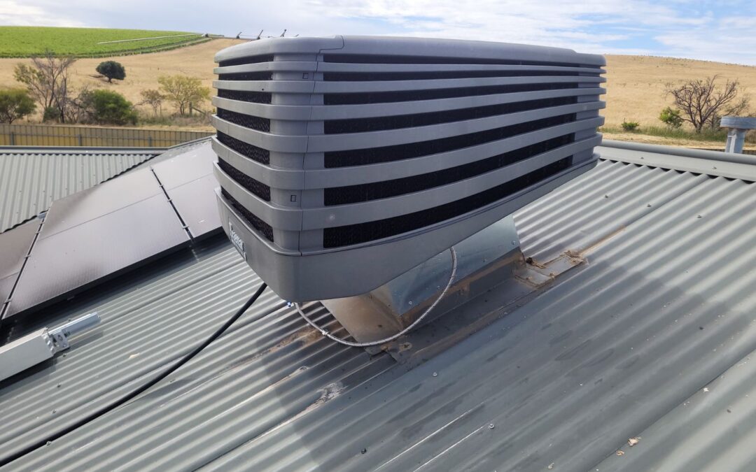 Evaporative cooling unit on roof next to solar panels